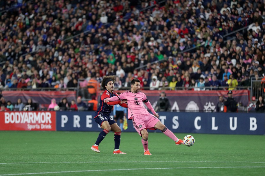 Inter Miami’s Lionel Messi fields the ball ahead of New England Revolution midfielder Ryan Spaulding in the second half at Gillette Stadium. - REUTERS PIC