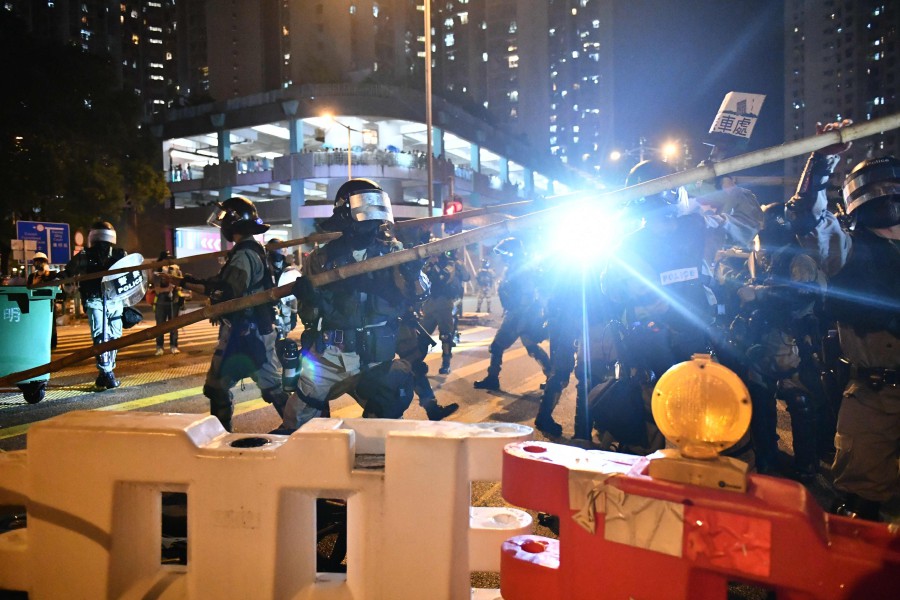 Police officers disassemble a barricade built by protesters in Tseung Kwan O Kowloon in Hong Kong. - AFP