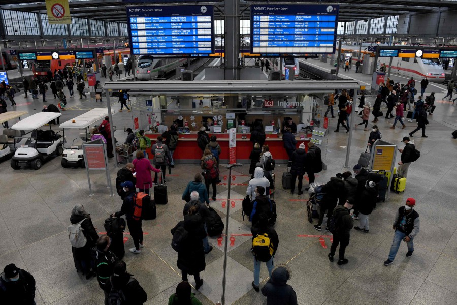 People line up in front of an information desk at the main railway station in Munich. - AFP PIC