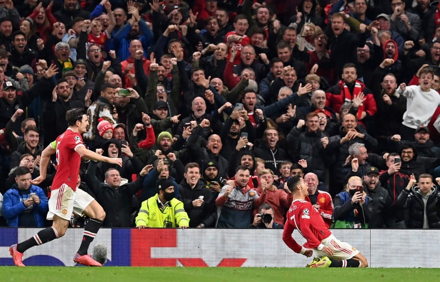 Manchester United's Portuguese striker Cristiano Ronaldo (C) celebrates scoring his team's third goal during the UEFA Champions league group F football match between Manchester United and Atalanta at Old Trafford stadium in Manchester. - AFP PIC