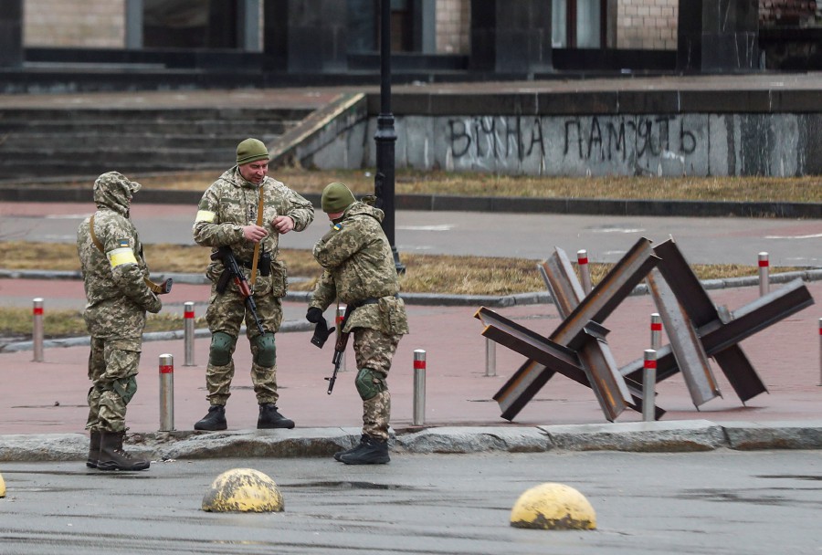 Ukrainian servicemen stand next to Czech hedgehogs in downtown Kyiv, Ukraine. - EPA PIC