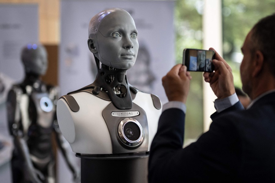 A visitor takes a picture of humanoid AI robot "Ameca" at the booth of Engineered Arts company during the world's largest gathering of humanoid AI Robots as part of International Telecommunication Union (ITU) AI for Good Global Summit in Geneva. - AFP PIC