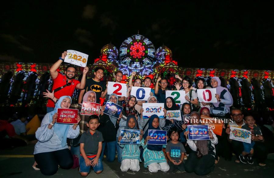 Public members hold Year 2020 placards ahead of the celebration in Putrajaya. -NSTP/Luqman Hakim Zubir