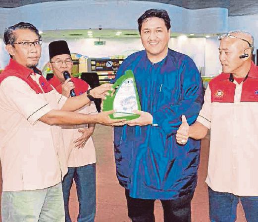 Abdul Fattah Hamid (left) presenting a sample of the GTO engine oil to Datuk Tengku Putra Haron Aminurrashid Tengku Hamid Jumat.