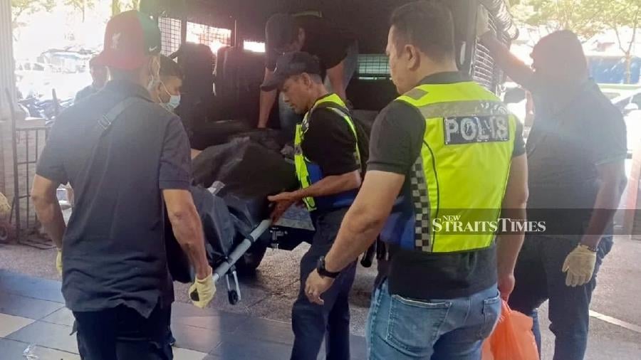 Police officers carrying the remains of the victim at the Desa Mentari flats. - NSTP/Muhaamad Hafis Nawawi