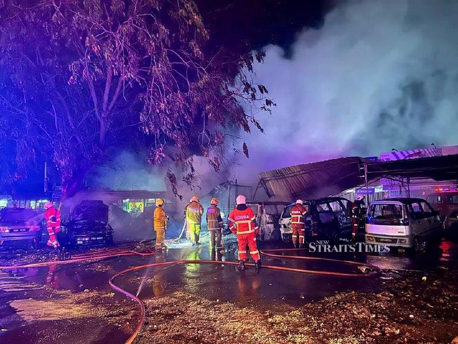 Firefighters are on the scene after a fire razed 16 vehicles in Taman Keladi. -Pic courtesy of Fire and Rescue Dept