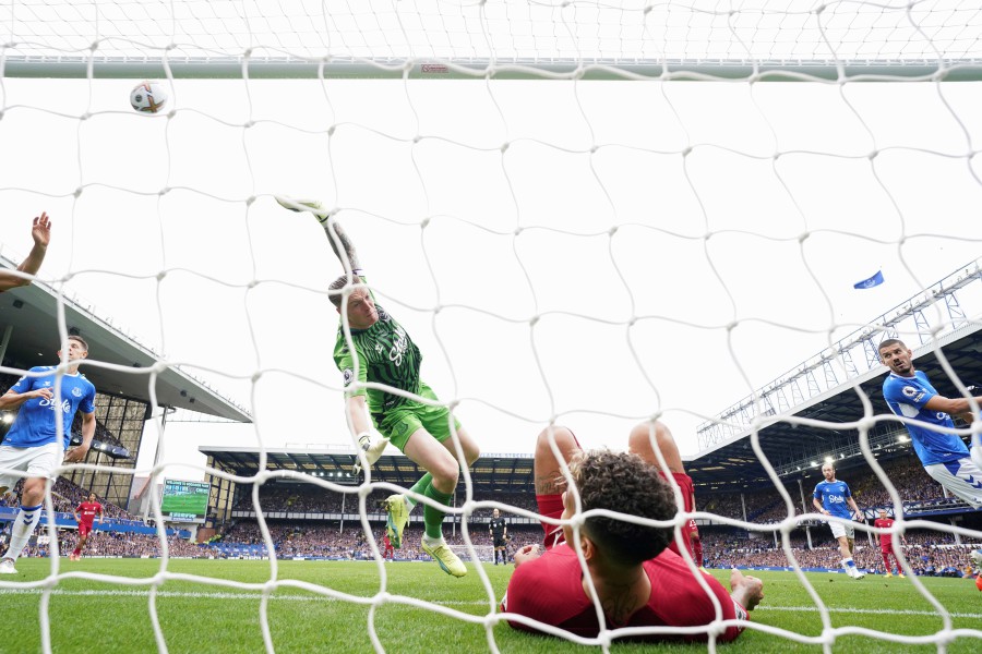 Everton's goalkeeper Jordan Pickford saves a ball as Liverpool's Roberto Firmino falls in the net during the English Premier League at Goodison Park, Liverpool. - AP PIC