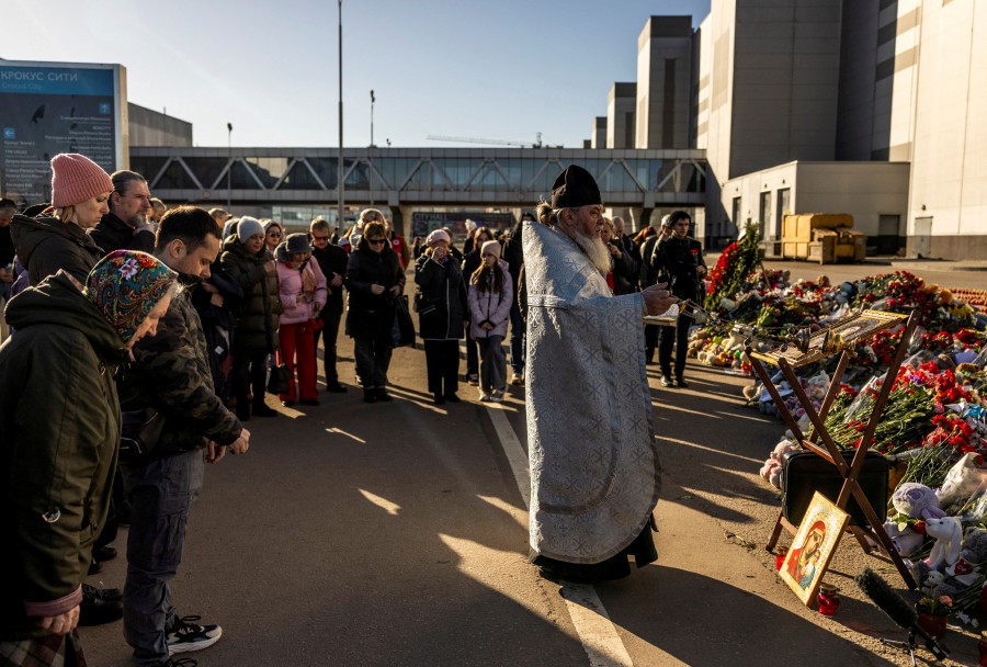 A priest conducts a service near the Crocus City Hall following a deadly attack on the concert venue in the Moscow Region, Russia. -REUTERS PIC