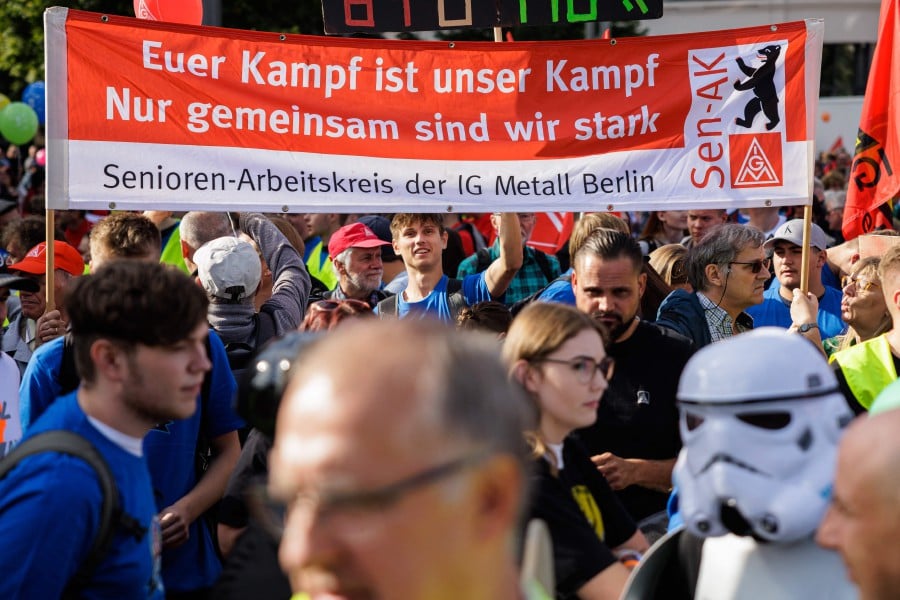 People hold a banner reading "Your fight is our fight - only together we are strong - seniors work group of the IG MEtall Berlin" during a demonstration of Germany's metal workers union IG Metall (IGM) in the city centre of Leipzig, eastern Germany. - APF PIC