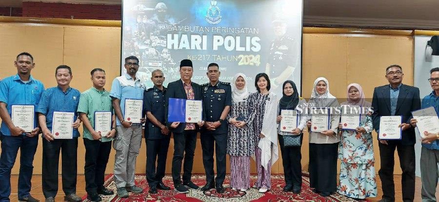 Kuantan police chief Assistant Commissioner Wan Mohd Zahari Wan Busu (standing middle) after presenting certificates of appreciation to members of the public during the district-level 217th Police Day celebration at Indera Mahkota. - NSTP/T.N. Alagesh