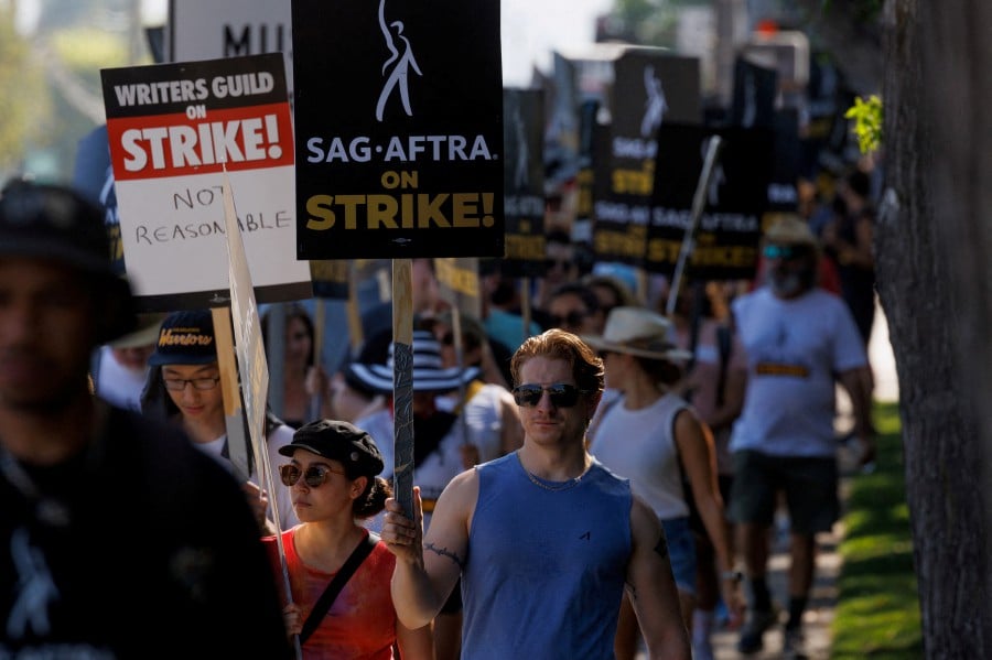 SAG-AFTRA actors and Writers Guild of America (WGA) writers walk the picket line outside Disney Studios in Burbank, California on July 25, 2023. - REUTERS PIC