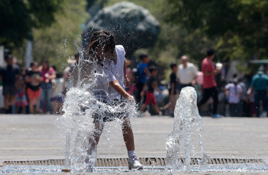 A girl cools herself down in a water fountain during a heat wave hitting the country in Guadalajara, Jalisco state, Mexico. - AFP PIC