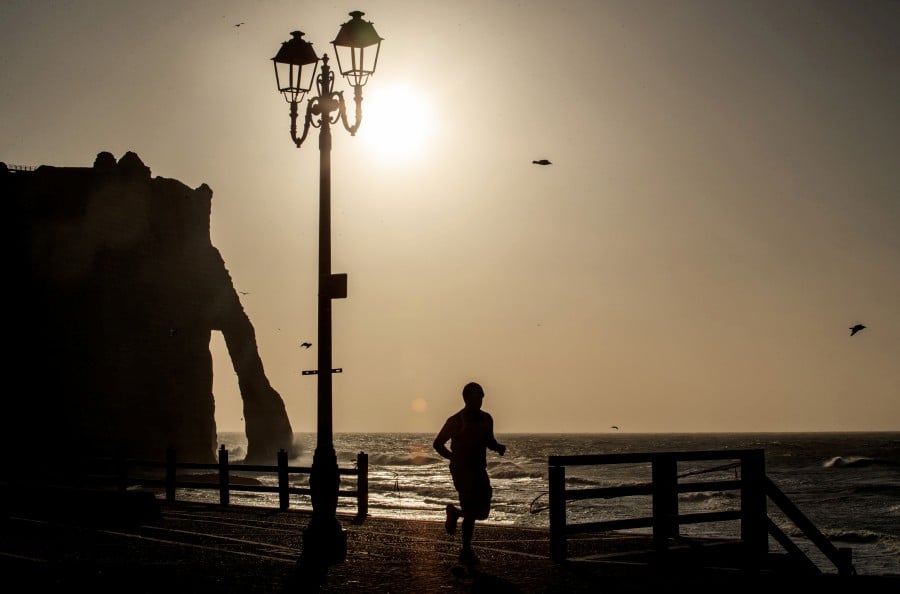 A jogger runs near the cliffs of Etretat, northwestern France, on April 13, 2020, on the 28th day of a lockdown in France aimed at curbing the spread of the COVID-19 pandemic, caused by the novel coronavirus. - AFP