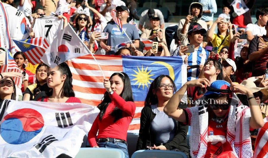 Malaysian and South Korean fans cheer on during the Qatar 2023 AFC Asian Cup Group E football match between South Korea and Malaysia at Al-Janoub Stadium in al-Wakrah. -NSTP/HAIRUL ANUAR RAHIM