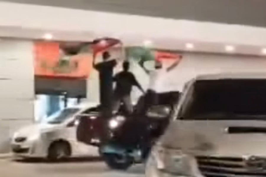 A screengrab of the men standing at the rear of a four-wheel-drive vehicle outside a fast food outlet in Kuantan. - Screengrab from 'I Love Pahang' FB page