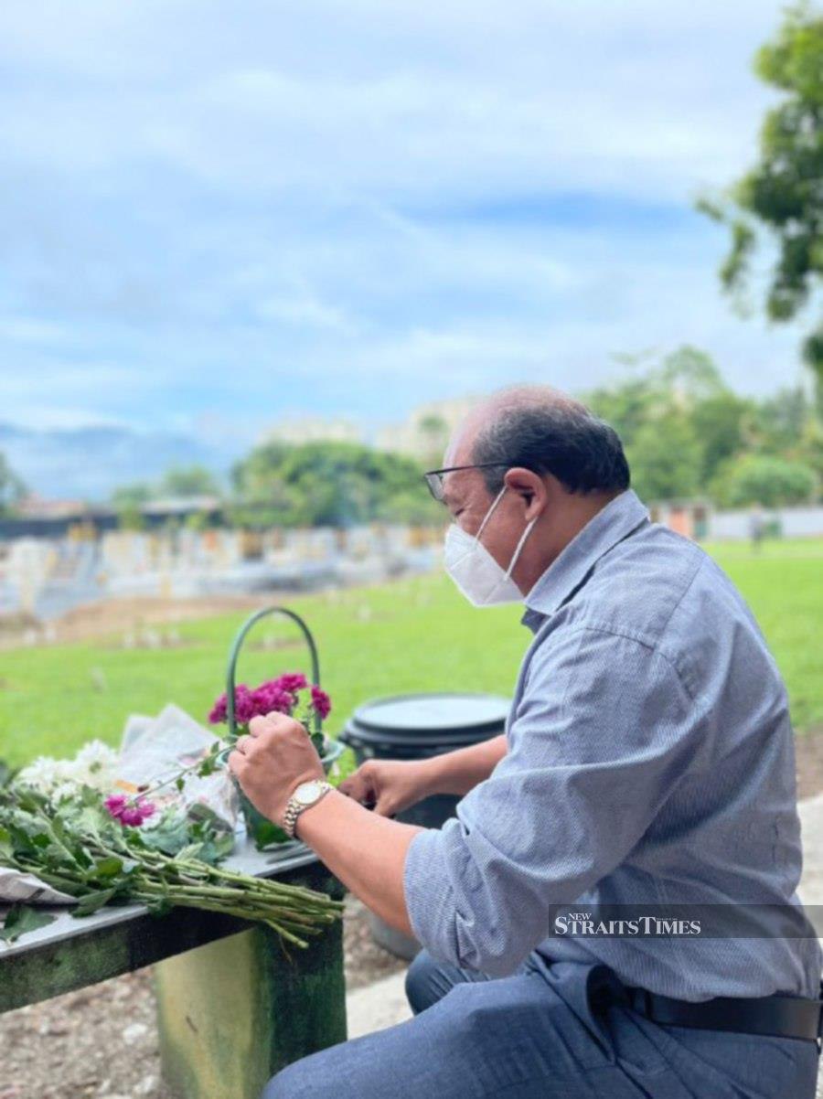  Church of the Immaculate Conception parishioner Max D’Almeida arranges flowers for his mother’s grave. - Pix by Marina Emmanuel 