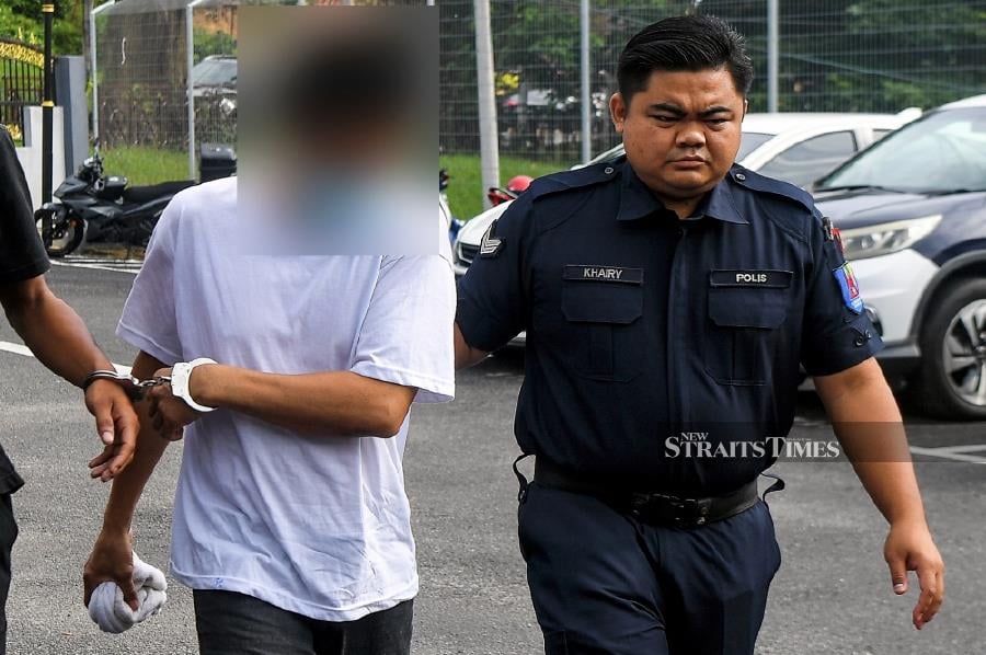 The accused (left) is seen arriving at the Kuala Pilah Sessions Court ahead of the trial. -BERNAMA PIC 
