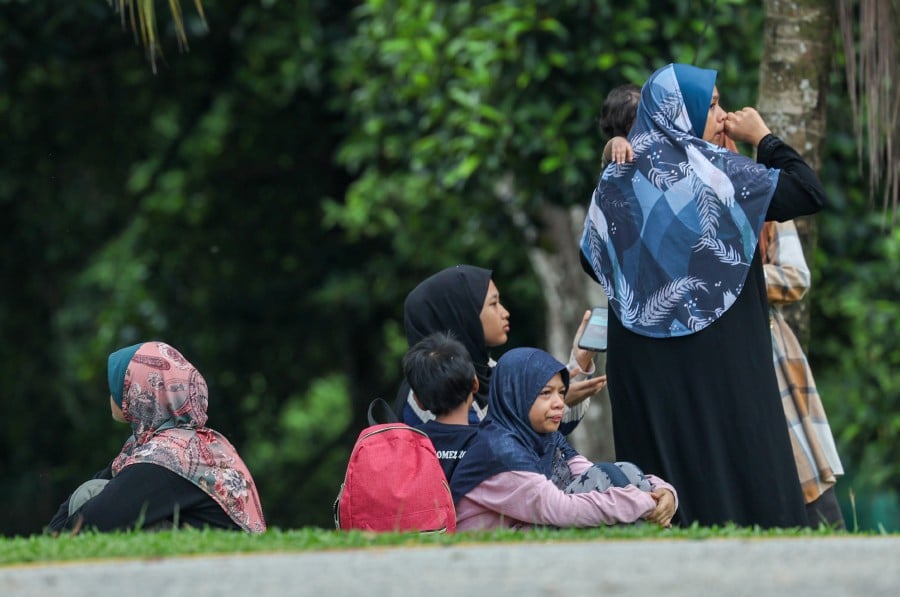 Family members waiting outside the Kuala Kubu Baharu Hospital’ Forensic Unit. -- BERNAMA PIC