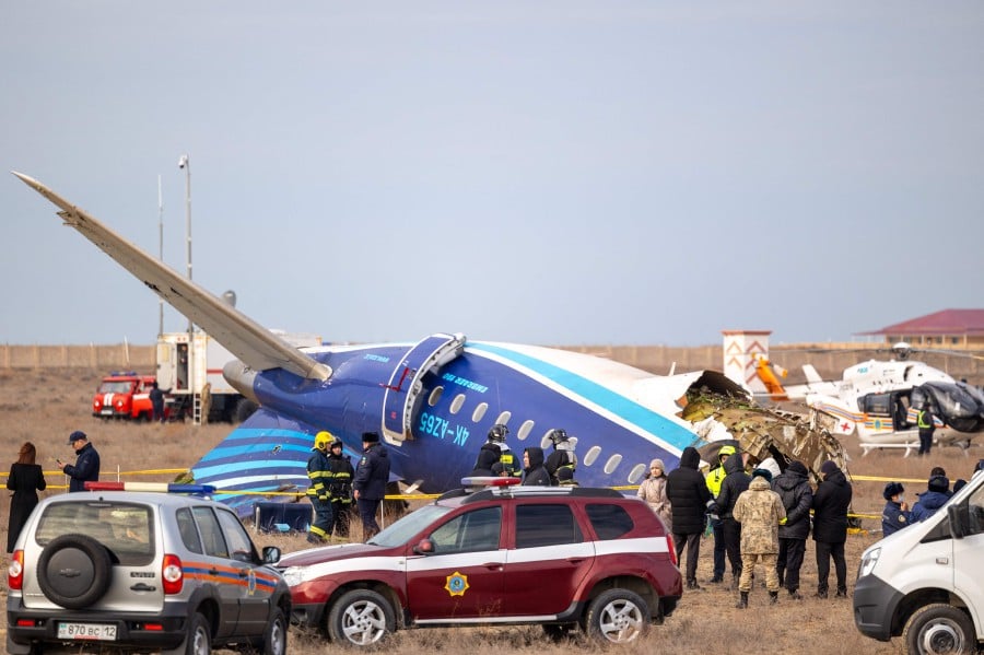 Emergency specialists work at the crash site of an Azerbaijan Airlines passenger jet near the western Kazakh city of Aktau on Dec 25. -- AFP