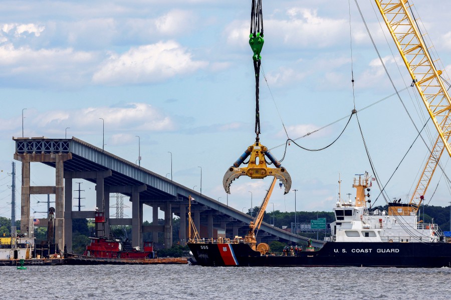 A U.S. Coast Guard boat approaches clean-up operations at the Francis Scott Key Bridge as the main shipping channel prepares to fully reopen, in Baltimore, Maryland, U.S., June 10, 2024. -- REUTERS