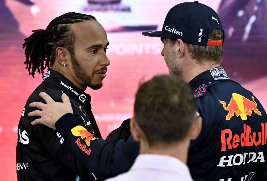 2021 FIA Formula One World Champion Red Bull's Dutch driver Max Verstappen (R) greets second-placed Mercedes' British driver Lewis Hamilton (L) after the Abu Dhabi Formula One Grand Prix at the Yas Marina Circuit on December 12, 2021. - AFP PIC