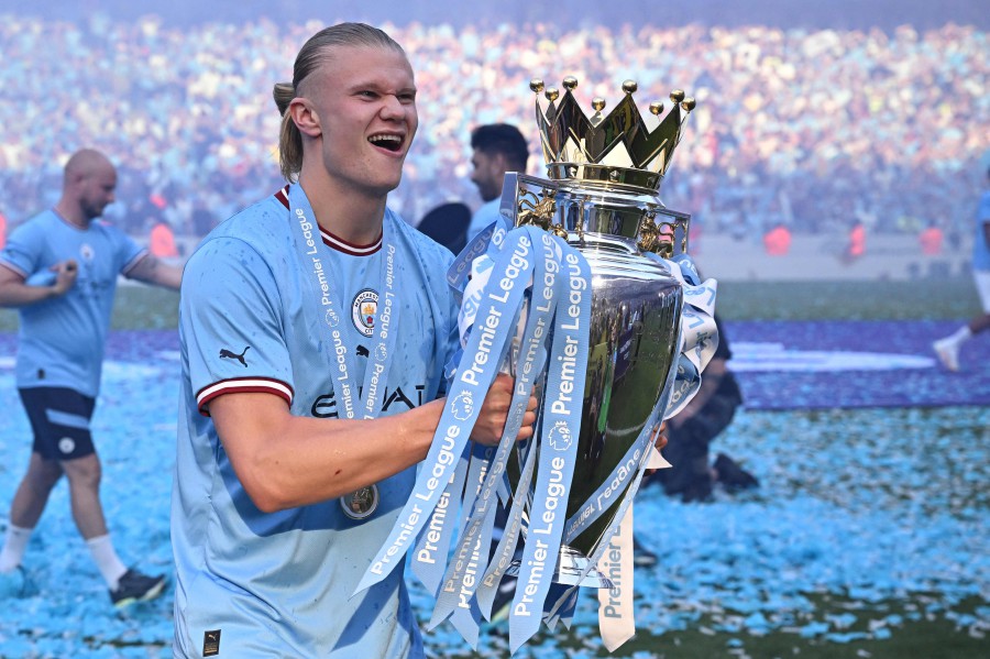 Manchester City's Norwegian striker Erling Haaland poses with the Premier League trophy on the pitch after the presentation following the English Premier League football match between Manchester City and Chelsea at the Etihad Stadium in Manchester, north west England, on May 21, 2023. -AFP PIC