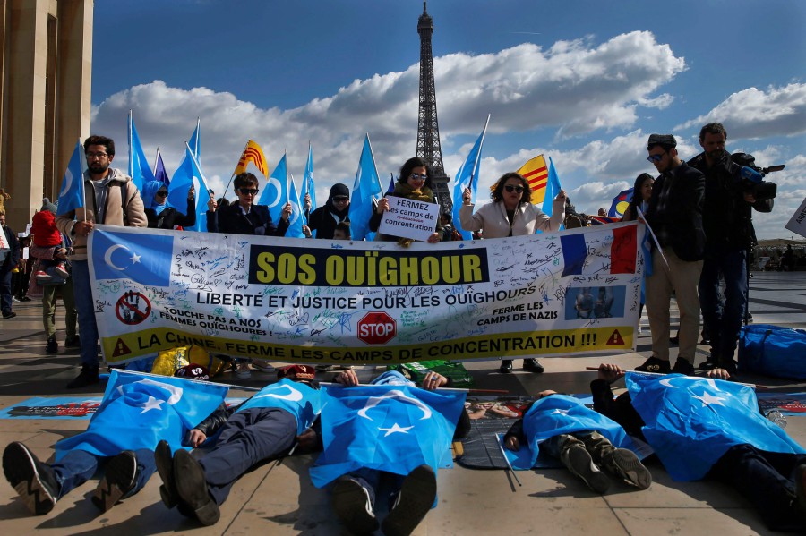  In this file photo taken on March 25, 2019 Protesters of the French Uyghur Community shout slogans and hold flags of East Turkestan (or Uighur flags) during a demonstration over China's human rights record near the Eiffel Tower on the Trocadero esplanade in Paris during a state visit of the Chinese president. - AFP PIC