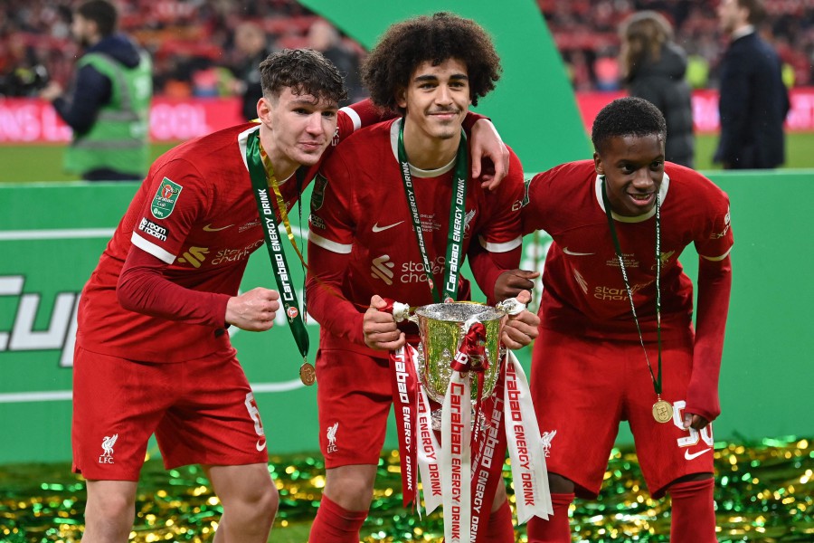 Liverpool's Lewis Koumas (L), Jayden Danns (C) and Liverpool's Treymaurice Nyoni pose with the trophy following the English League Cup final football match between Chelsea and Liverpool at Wembley stadium, in London. - AFP PIC