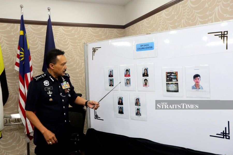  Perak police chief Datuk Seri Mohd Yusri Hassan Basri points at pictures of suspects allegedly involved in the illegal gambling activities, during a press conference at the state police contingent headquarters in Ipoh. - NSTP/L.MANIMARAN