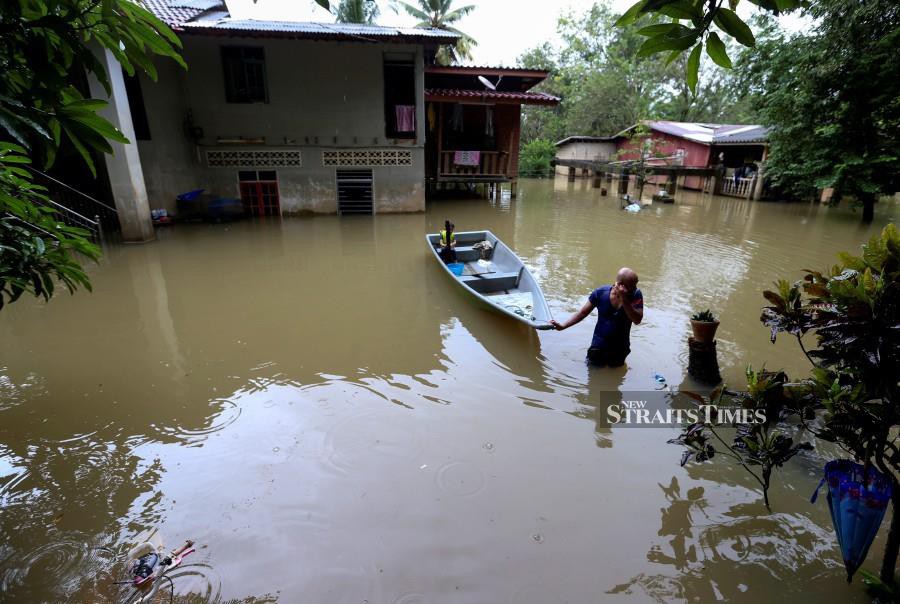 A resident of Kampung Tersang in Rantau Panjang, utilises a boat for his transportation following the floods in Kelantan. -NSTP/NIK ABDULLAH NIK OMAR