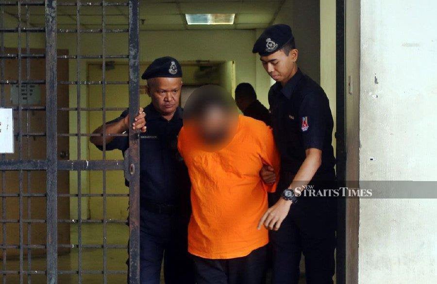 Policemen escort the accused at the Kota Star district police headquarters. - NSTP/AHMAD MUKHSEIN MUKHTAR