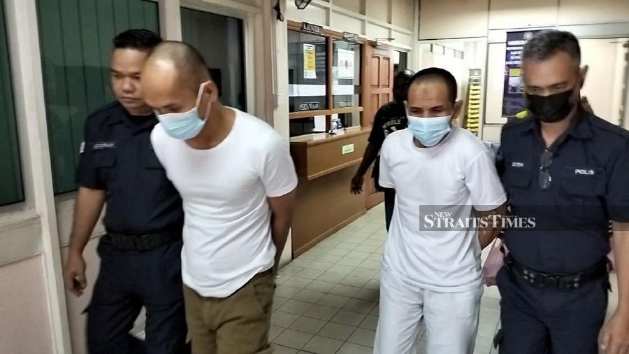 Nedzmar Palaudin (2nd-left) and Jakaria Abu Bakar (2nd-right) are escorted by policemen following their trial at the Tawau High Court. - NSTP/Abdul Rahemang Taiming.