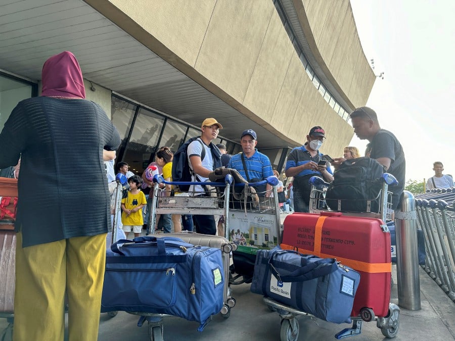 Passengers wait outside the Ninoy Aquino International Airport Terminal 1 in Pasay City, Metro Manila, Philippines. - REUTERS PIC