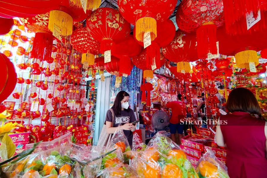 Customers buying Chinese New Year decorations at a store in Melaka today. -NSTP/SYAFEEQ AHMAD