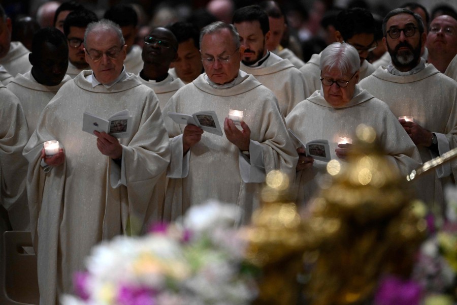 Priests hold candles during the Easter vigil as part of the Holy Week celebrations, at St Peter's Basilica in the Vatican on March 30, 2024. -- Pic: AFP