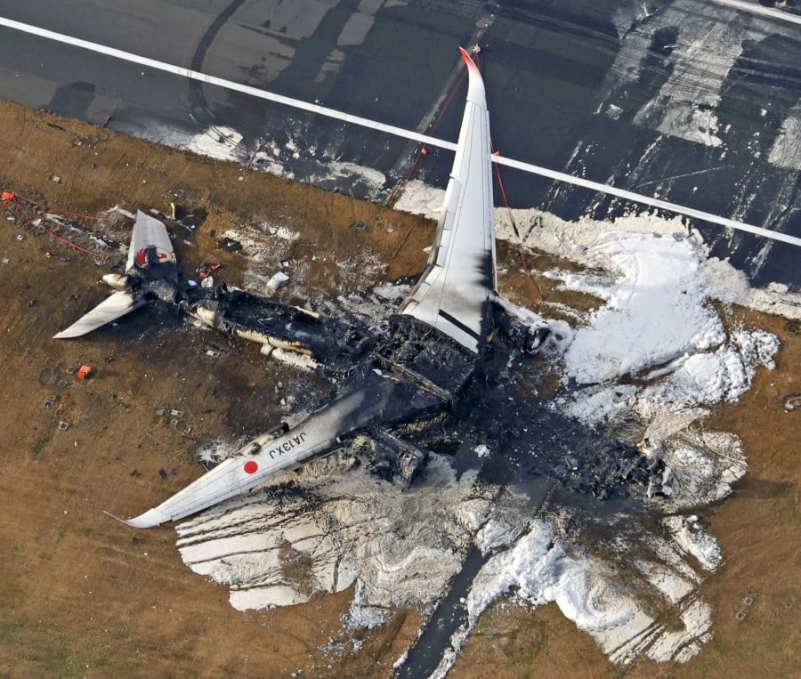 An aerial view shows burnt Japan Airlines' (JAL) Airbus A350 plane after a collision with a Japan Coast Guard aircraft at Haneda International Airport in Tokyo. - REUTERS PIC