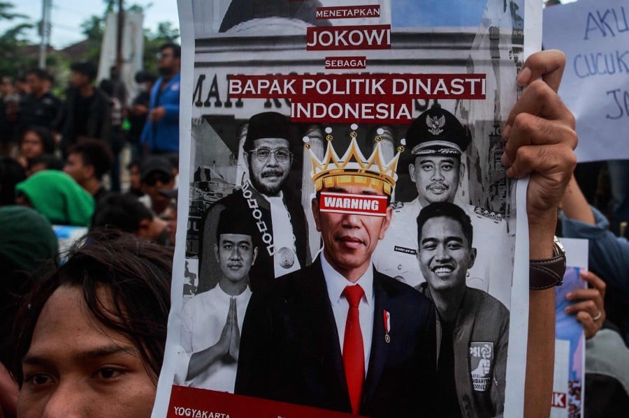 A student holds a poster showing Indonesia’s President Joko Widodo and his family members as hundreds of students protest against his family's political dynasty in the 2024 elections in Yogyakarta. - AFP PIC