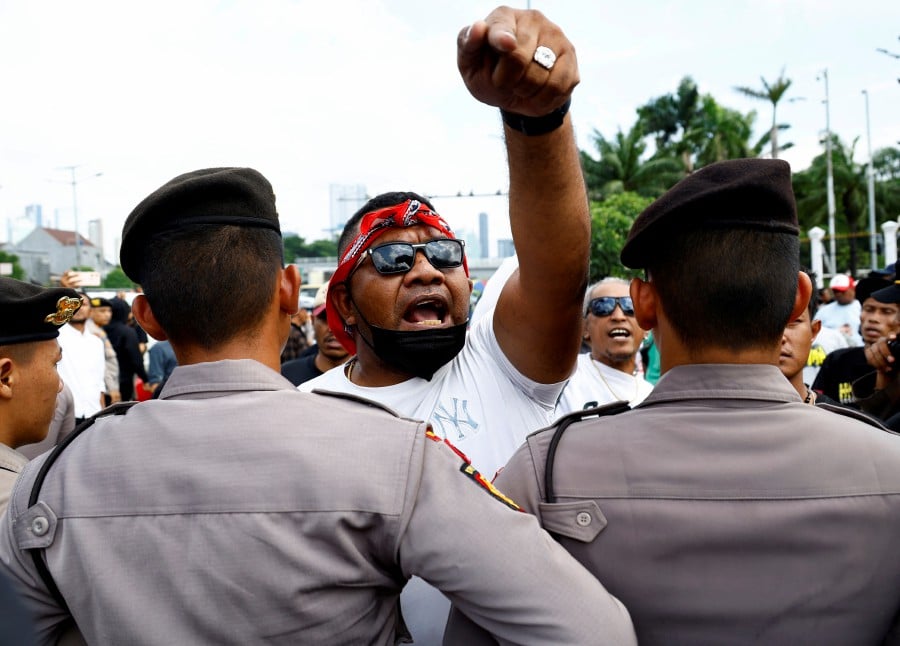 Police officers block pro-government protesters as they approach anti-government protesters who hold a rally demanding a fair election, outside the Indonesian parliament in Jakarta, Indonesia. - REUTERS PIC