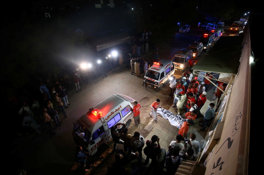  Rescue workers transport bodies of the victims of a bus fire to a mortuary in Karachi, Pakistan. - EPA PIC