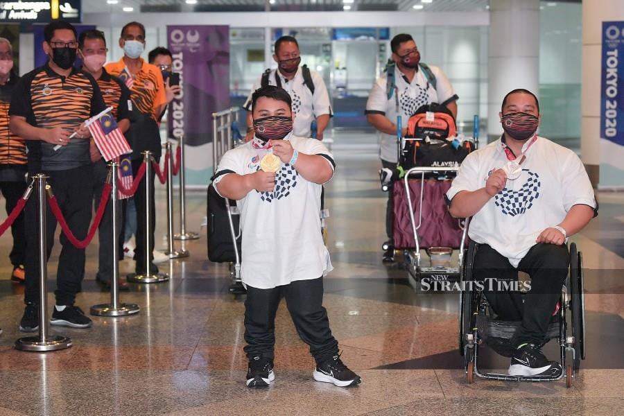  Bonnie Bunyau Gustin (left) and Jong Yee Khie (right) gesture as they arrive at the Kuala Lumpur International Airport (KLIA) in Aug 31. - BERNAMA PIC