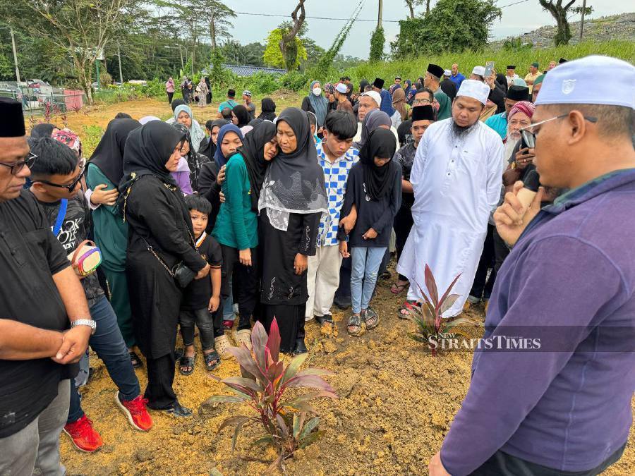 Family members of the decease, pay their last respects during the funeral at the Banang Jaya Muslim cemetery. - NSTP/Alias Abd Rani