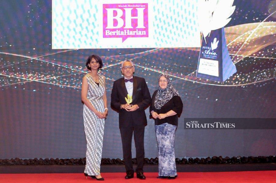  NSTP group managing editor and Berita Harian group editor Datuk Ahmad Zaini Kamaruzzaman (centre) accepting the award during the Putra Aria Brand Awards ceremony in Petaling Jaya. - NSTP/AIZUDDIN SAAD