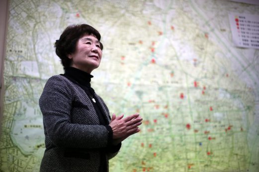 Haruyo Nihei speaks in front of a map of damaged area of 1945's Tokyo Firebombing at the Center of the Tokyo Raids and War Damage. Nihei was only 8-years-old when the biggest attack of the war, the firebombing of central Tokyo, killed over 100,000 people and left hundreds of thousands more homeless. She fled with her family and watched as many others were burned alive. As the flames swept over her, she was sheltered by her father and many others who piled on top of them who suffocated or burned to death. AP Photo