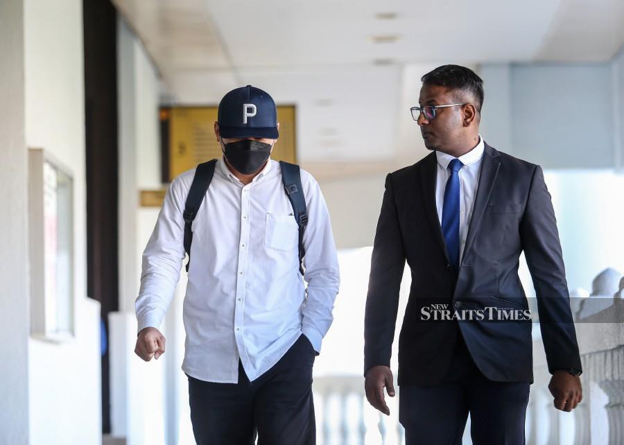 One of the accused (left) is seen arriving at the Kuala Lumpur Sessions Court ahead of the trial. - NSTP/ASWADI ALIAS