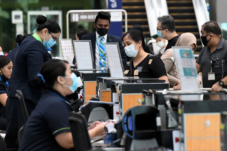 Passengers check in for a flight at Changi International Airport in Singapore on June 8, 2020, as Singapore prepares to reopen its borders after shutting them to curb the spread of the COVID-19 novel coronavirus-- AFP pic