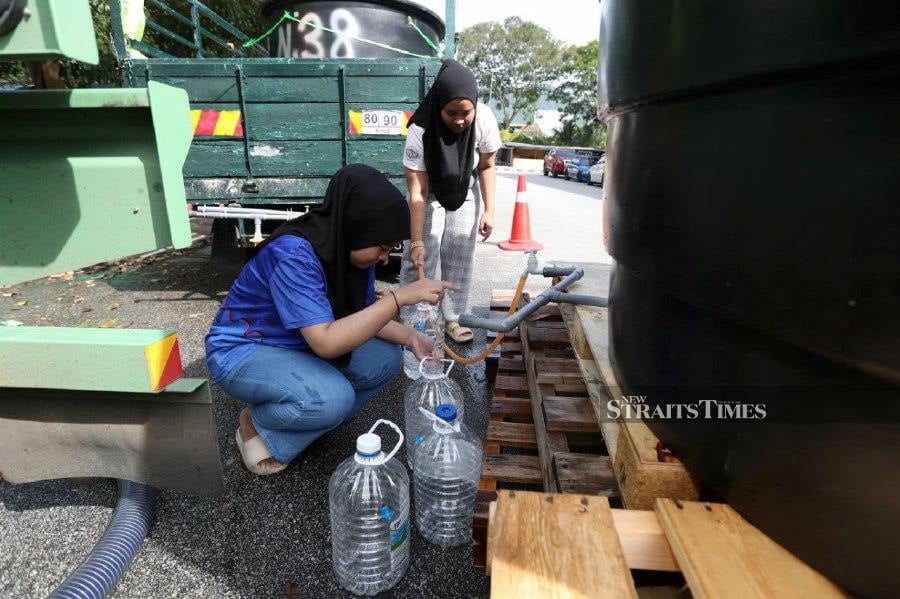 Residents of Bandar Baru Perda flats in Teluk Kumbar, seen filling up their water containers following water disruption in Penang. -NSTP/MIKAIL ONG