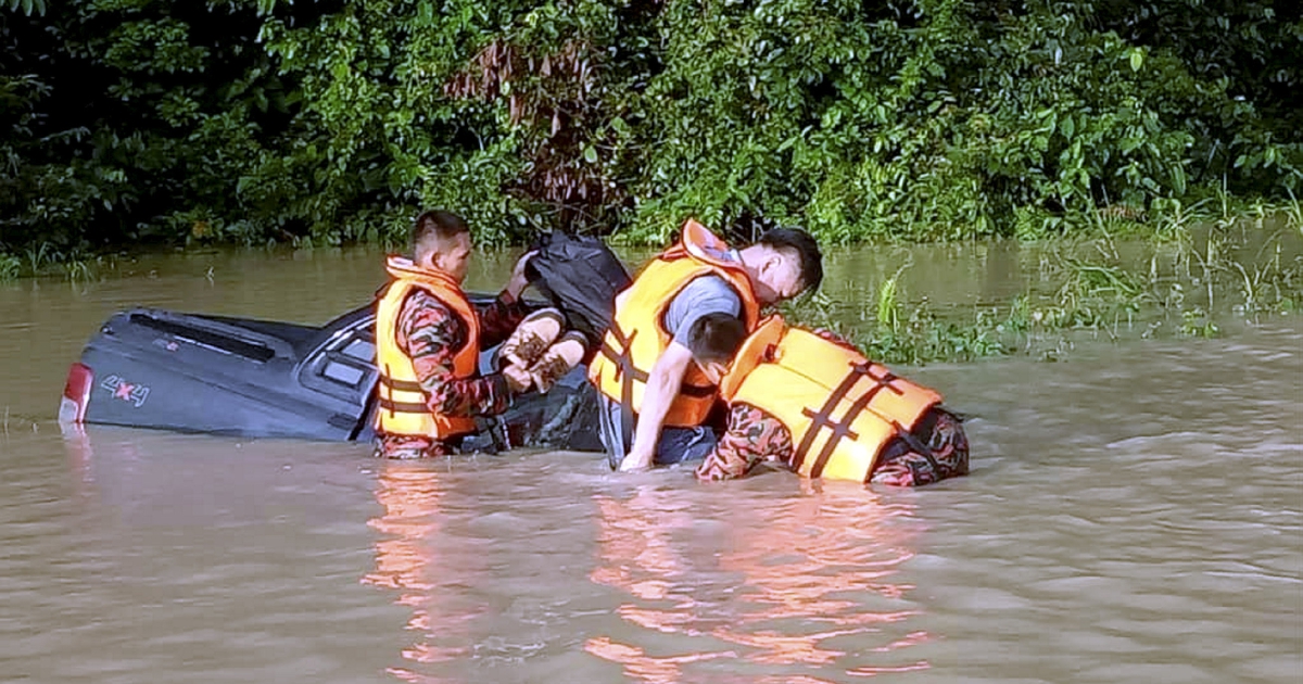 Rising floodwaters trap engineer on vehicle roof | New Straits Times