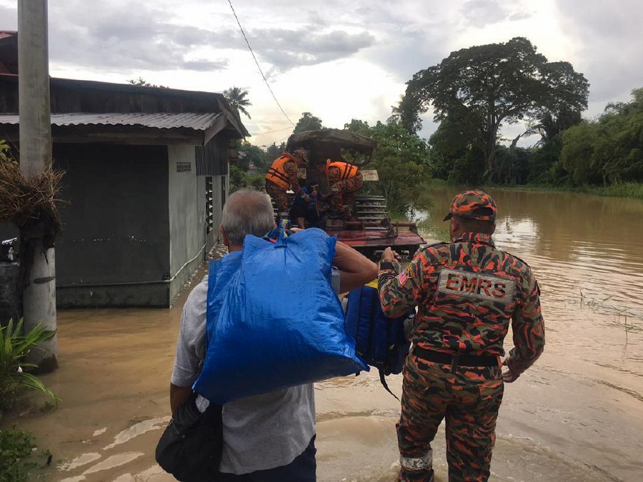 Rescuers help evacuate Kampung Alor Gunung residents following the floods. - Pic courtesy of Fire and Rescue Dept 