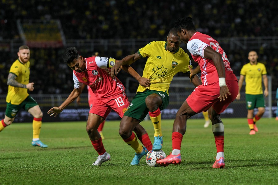 Kedah’s Jonathan Balotelli fights for the ball against two Police’s players during the match at the Darulaman Stadium. - BERNAMA PIC