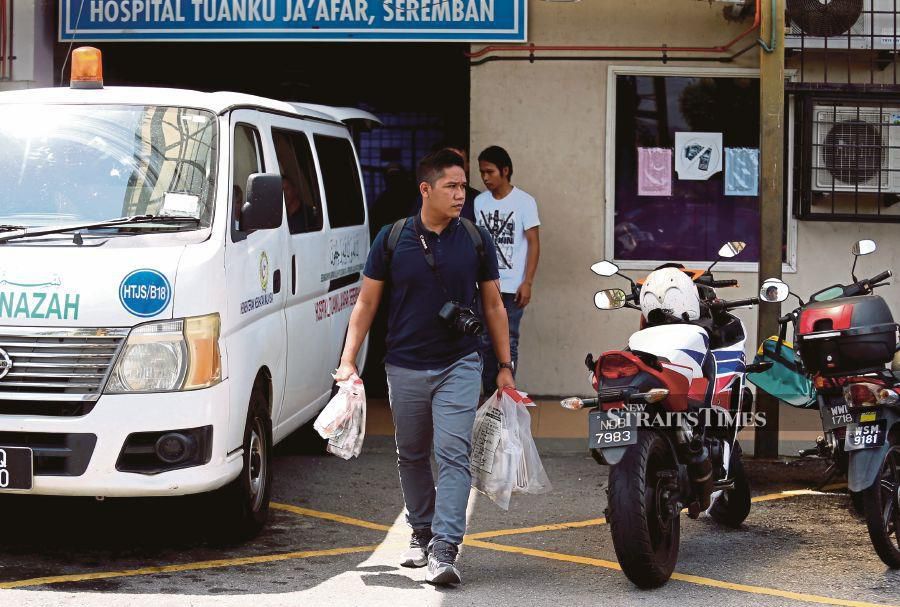 Police officers brought out cases for the post-mortem at Tuanku Jaafar Seremban Hospital Forensic Department (HTJS) over an elderly couple believed to have been killed and their house burned down at Taman Desa Melati. (NSTP/IQMAL HAQIM ROSMAN)